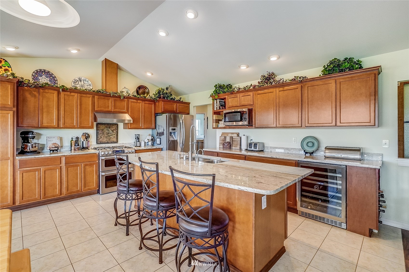 18039 Wild Violet Lane Southwest Rochester, WA 98579 - Photo 16 of 40 a kitchen with stainless steel appliances granite countertop a stove top oven a sink a dining table and chairs with wooden floor