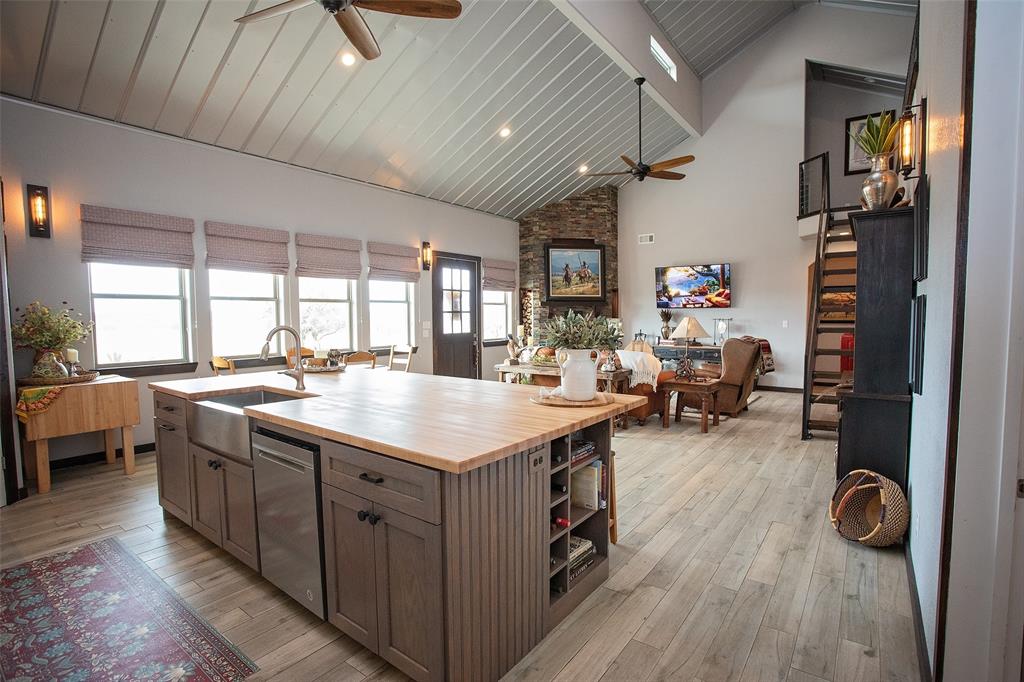 1982 Rocky Mound Road Graham, TX 76450 - Photo 35 of 35 Kitchen with butcher block counters, a kitchen island with sink, a ceiling fan, open floor plan, and vaulted ceiling