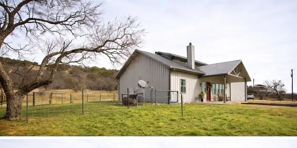 a view of swimming pool with lawn chairs and iron fence