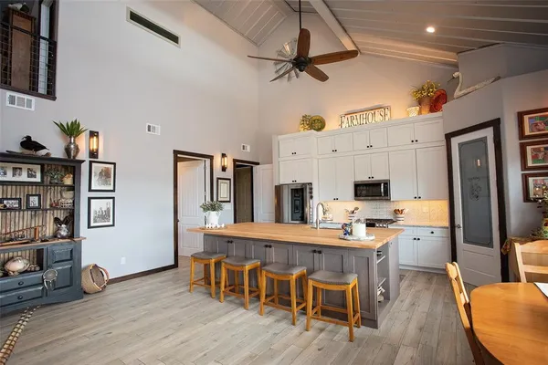 a kitchen with a dining table chairs and refrigerator
