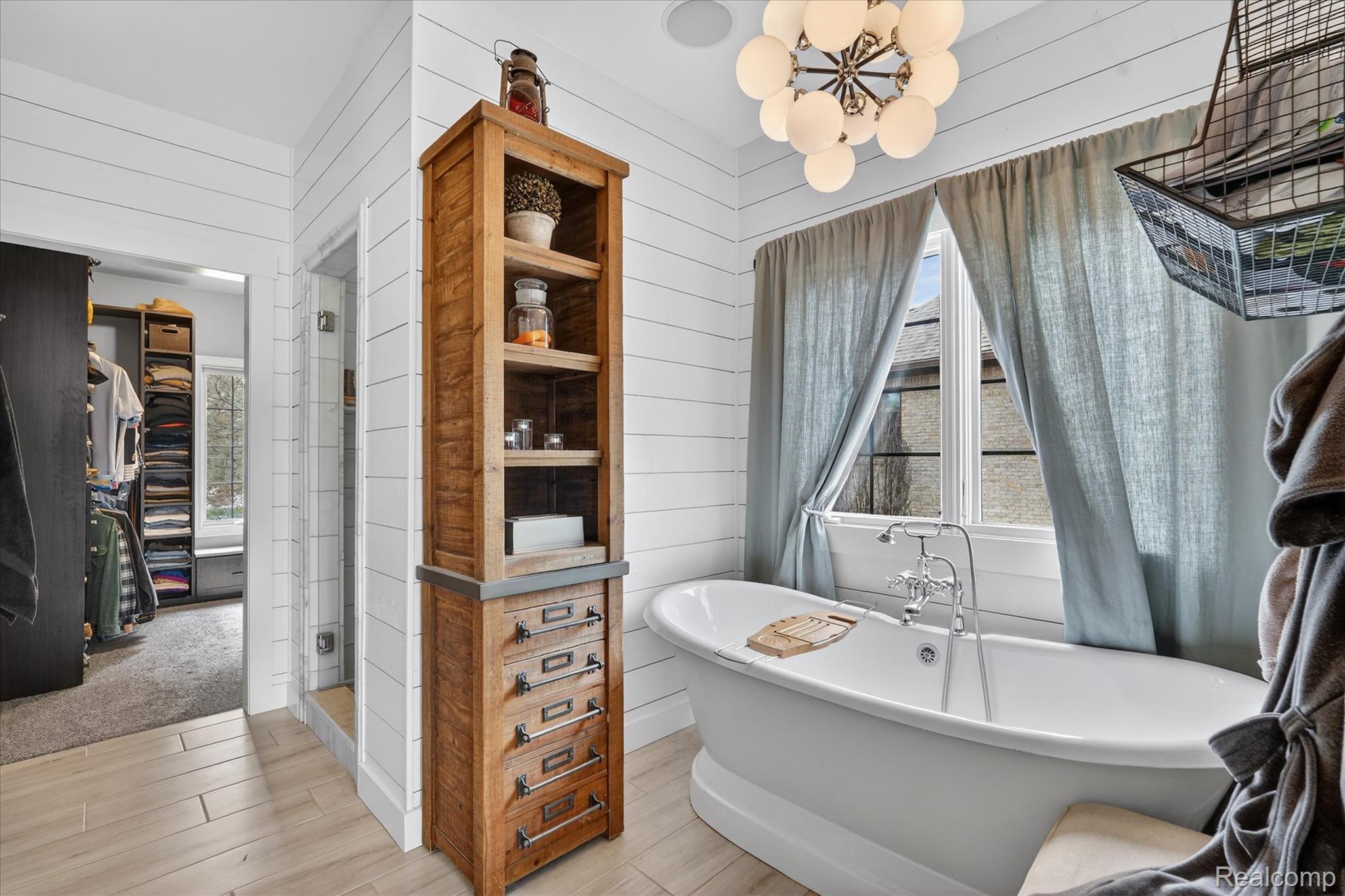 6932 Oakhurst Ridge Road Clarkston, MI 48348 - Photo 21 of 78 Full bath featuring a freestanding tub, wood walls, a spacious closet, wood tiled floors, and a shower stall