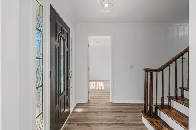 a view of a hallway with wooden floor and staircase