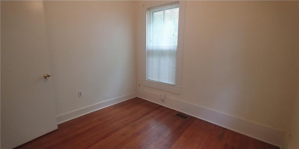 3205 Guadalupe Street, Unit A Austin, TX 78705 - Photo 12 of 17 a view of an empty room with wooden floor and a window