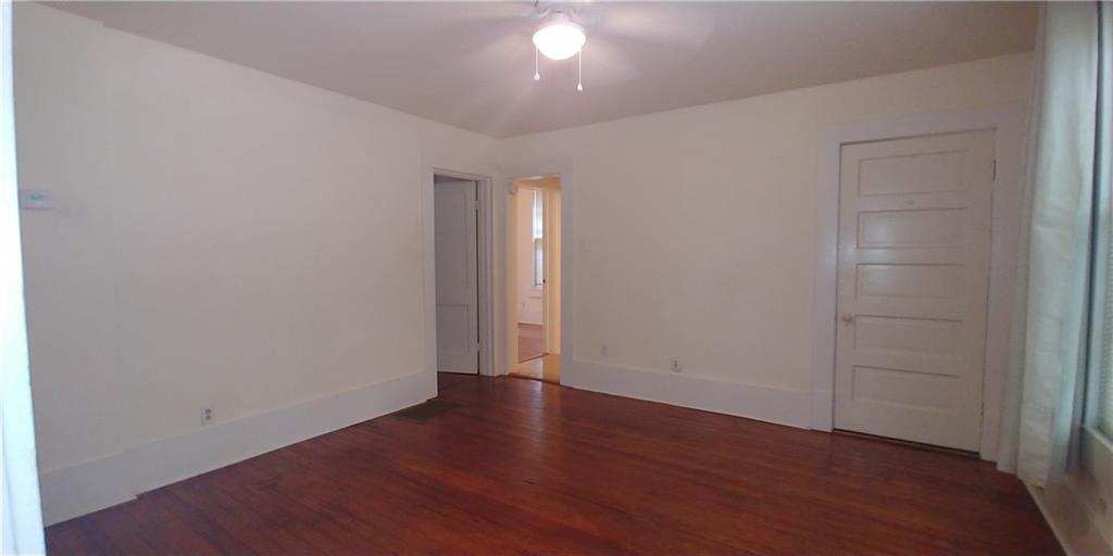 3205 Guadalupe Street, Unit A Austin, TX 78705 - Photo 3 of 17 an empty room with wooden floor and windows