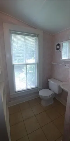 a bathroom with a toilet sink and window