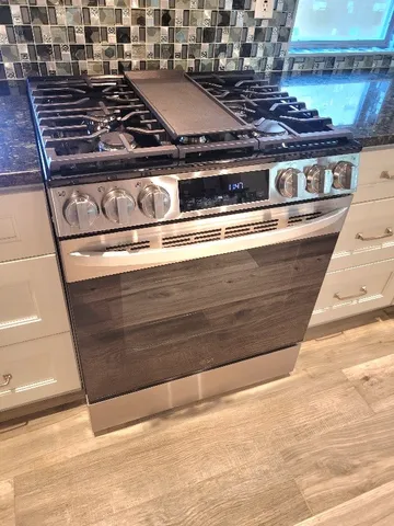 a stove top oven sitting inside of a kitchen
