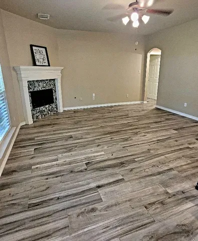 an empty room with windows and fan