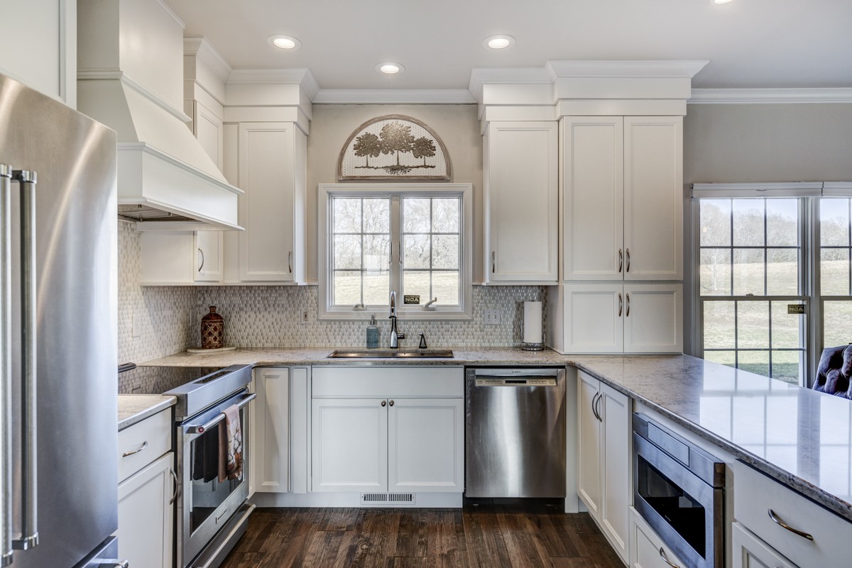 Beautifully renovated kitchen with high end appliances, custom cabinetry, and quartz countertops