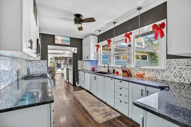 a kitchen with stainless steel appliances kitchen island granite countertop a refrigerator and a stove