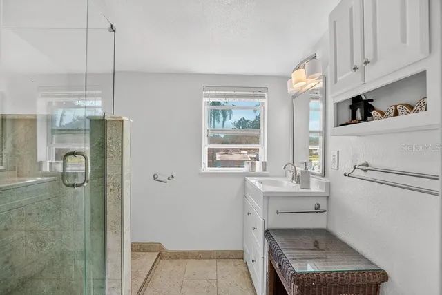 a view of a patio with a dining table and chairs under an umbrella with large trees
