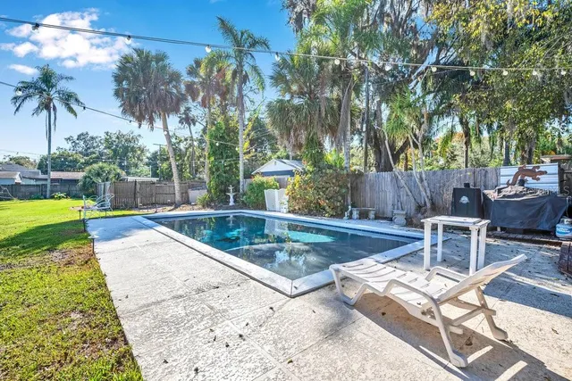 a view of a house with backyard and tree