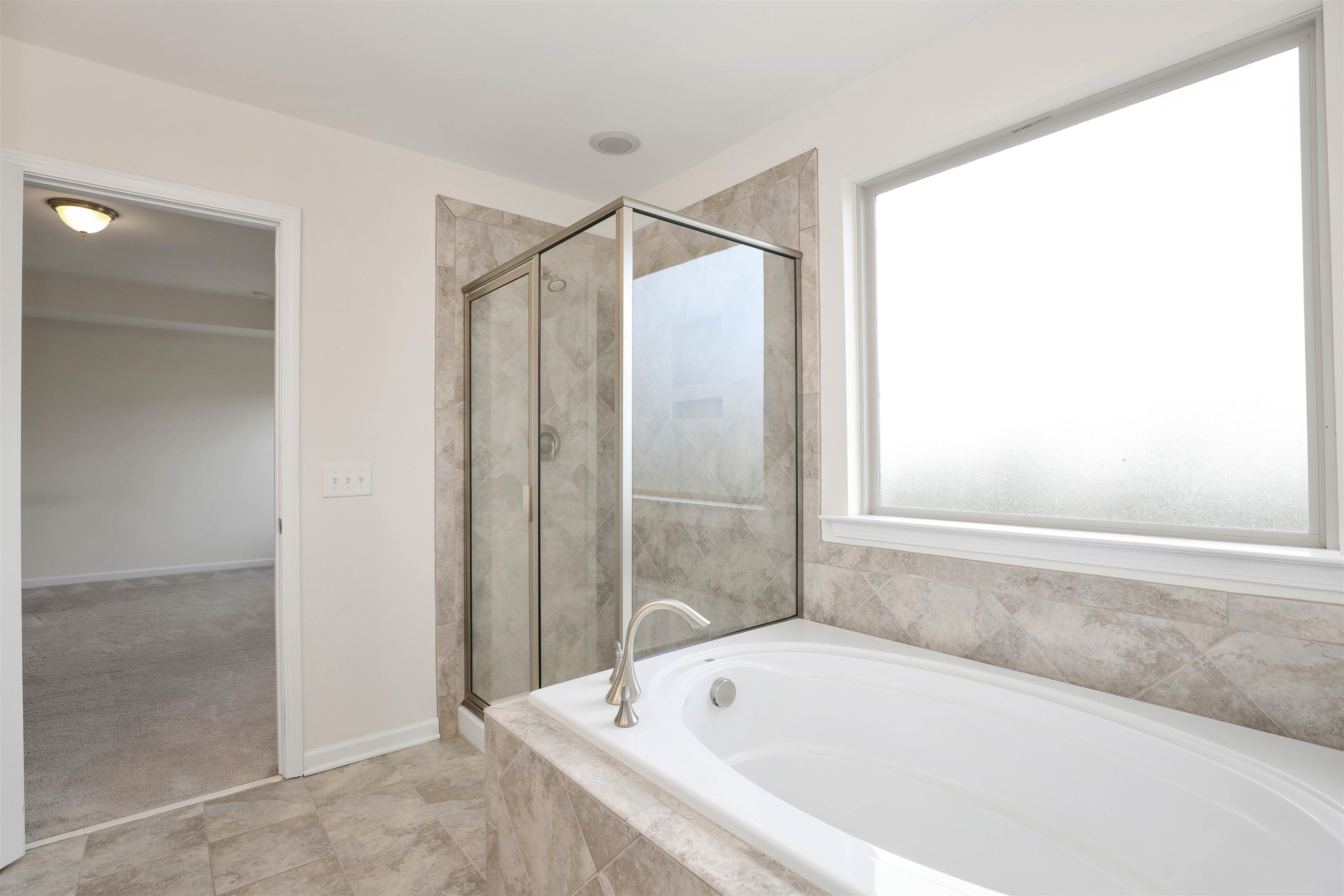 3413 Flat River Drive Durham, NC 27703 - Photo 26 of 40 a bathroom with a bathtub and a shower