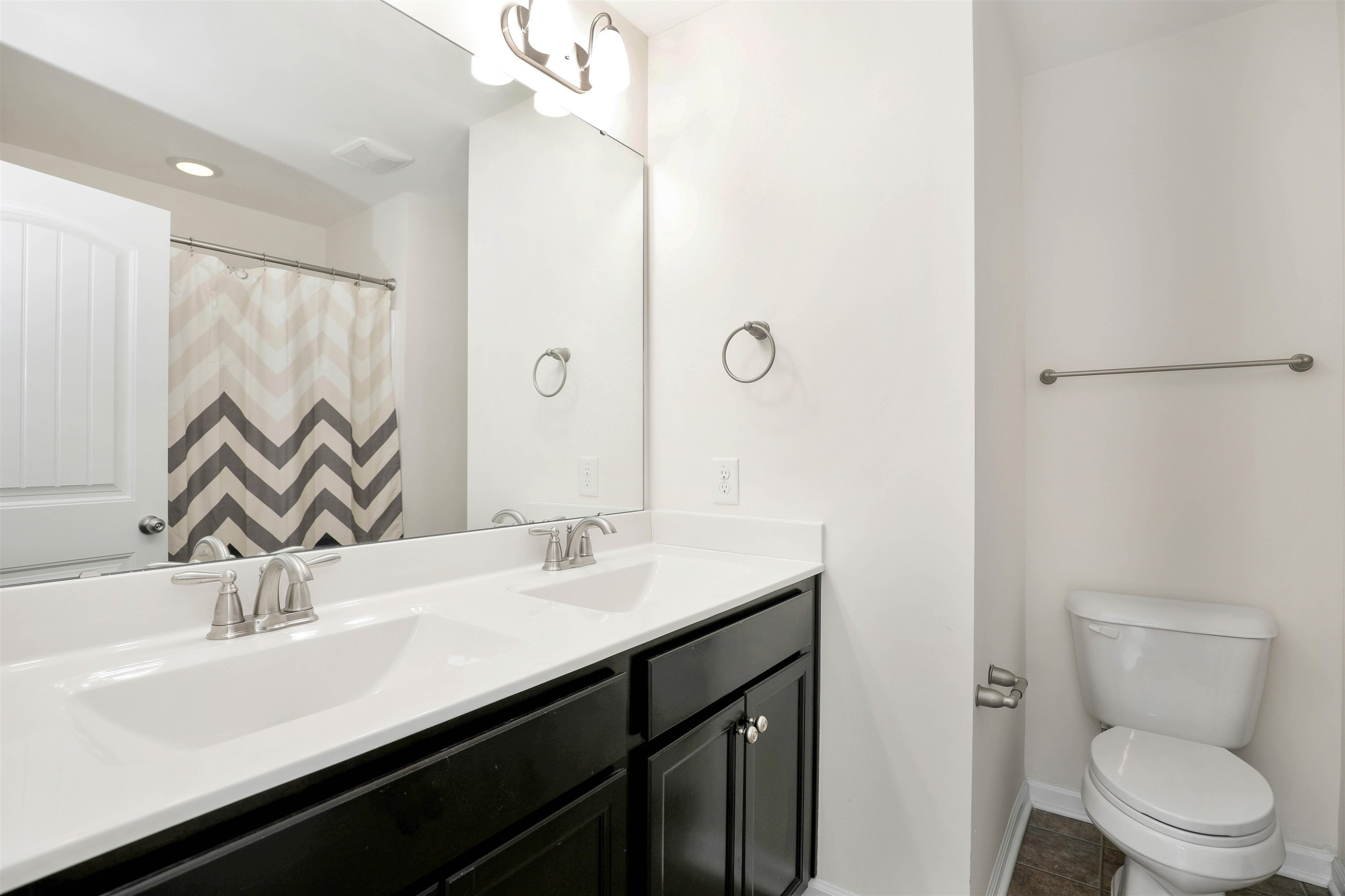 3413 Flat River Drive Durham, NC 27703 - Photo 32 of 40 a bathroom with a double vanity sink toilet and a mirror