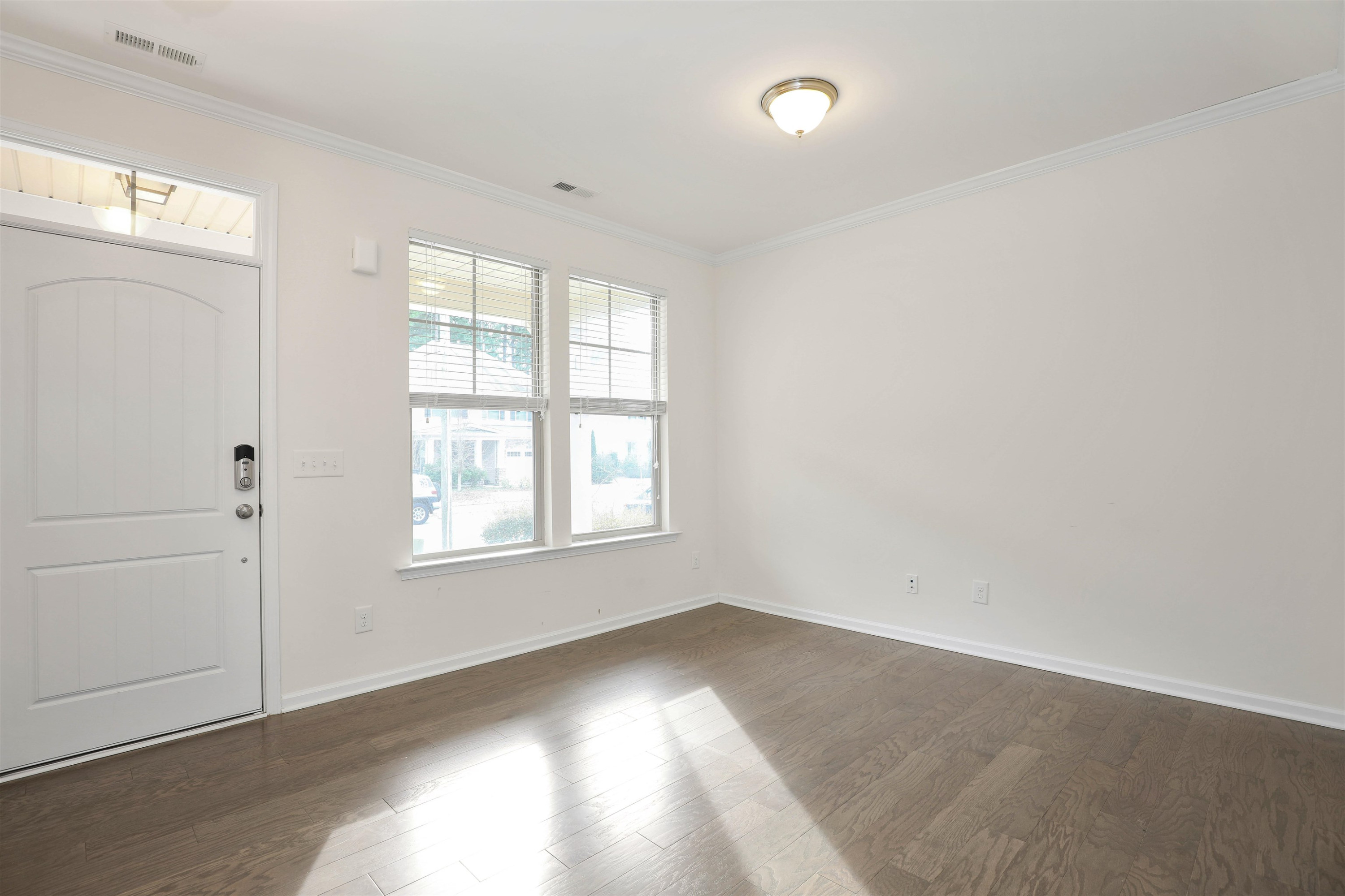 3413 Flat River Drive Durham, NC 27703 - Photo 6 of 40 an empty room with wooden floor and windows