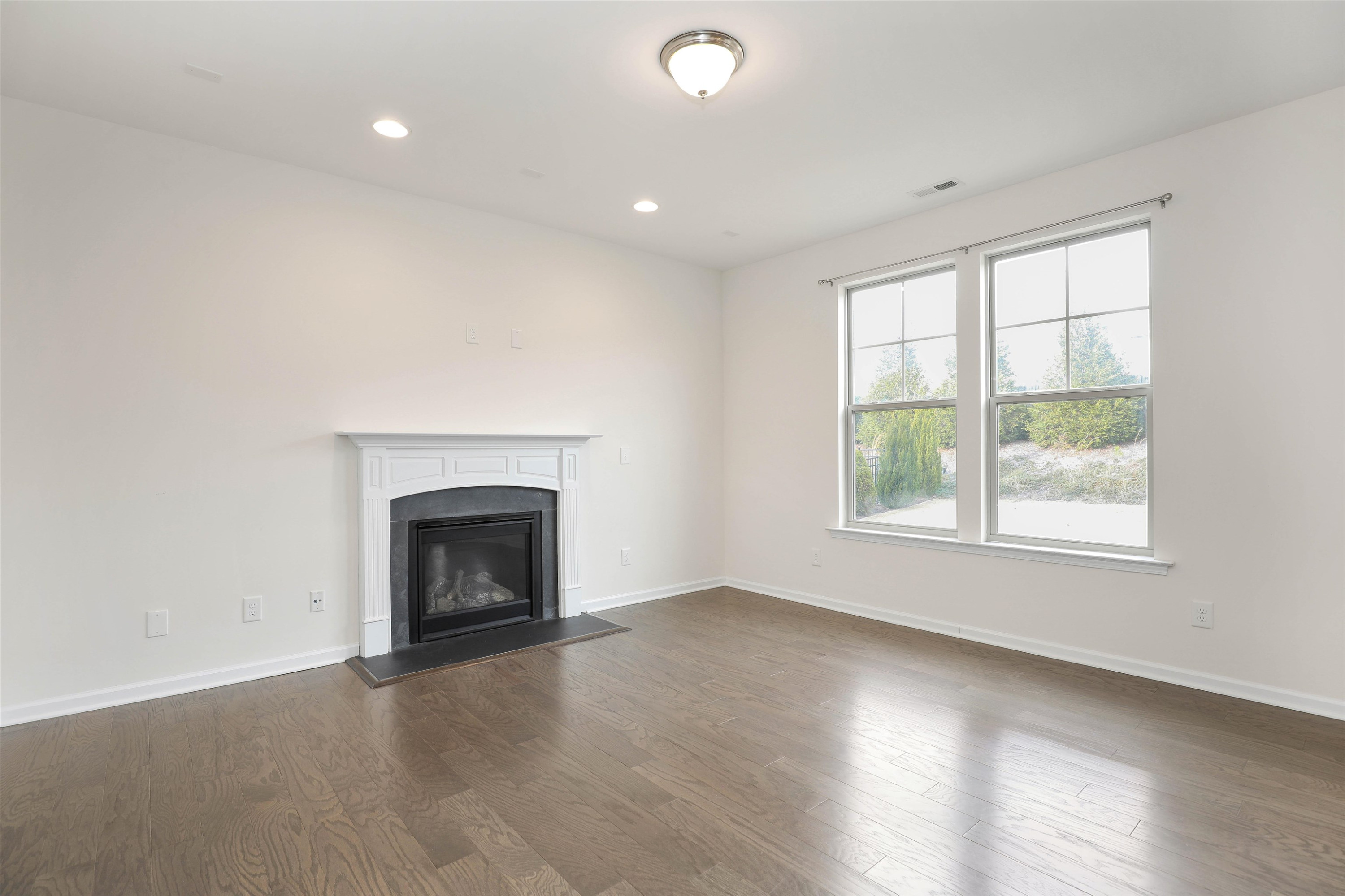 3413 Flat River Drive Durham, NC 27703 - Photo 8 of 40 an empty room with windows and fireplace