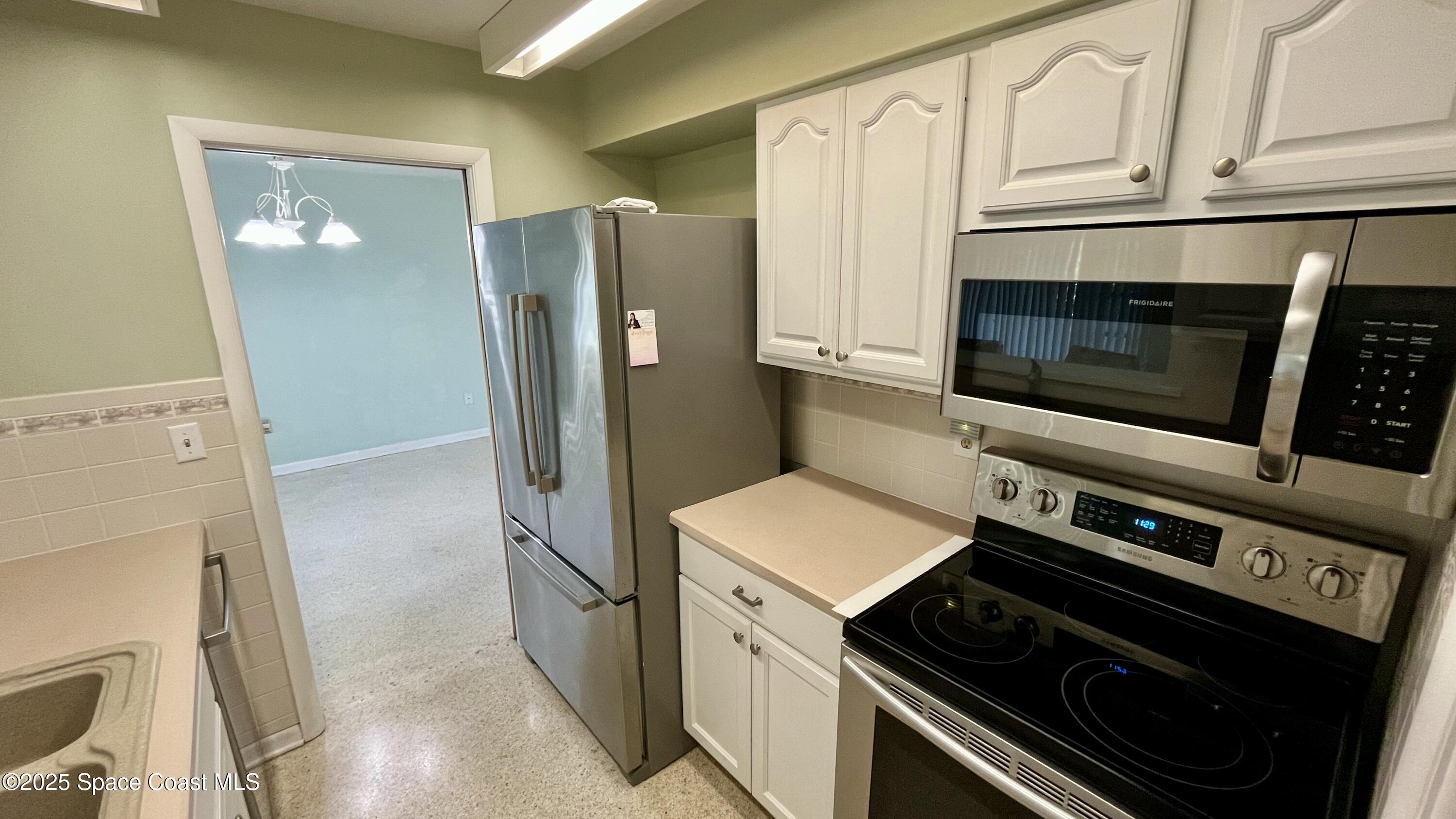 7181 Blue Shore Road Grant, FL 32949 - Photo 13 of 40 a kitchen with cabinets and steel stainless steel appliances