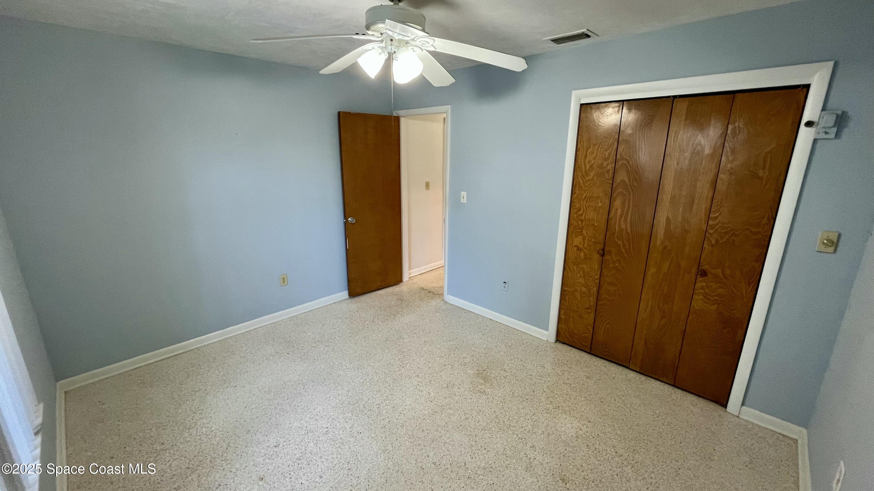 7181 Blue Shore Road Grant, FL 32949 - Photo 23 of 40 an empty room with closet and a chandelier fan