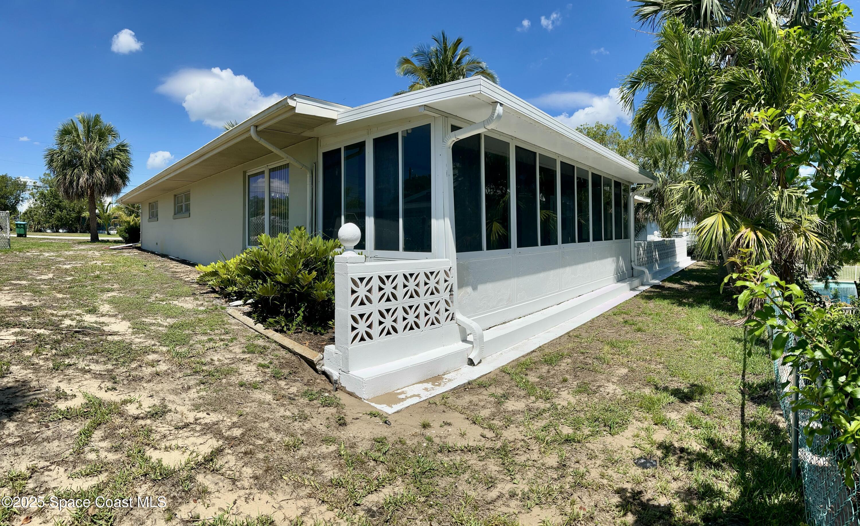7181 Blue Shore Road Grant, FL 32949 - Photo 39 of 40 a view of a white house with large windows and a small yard