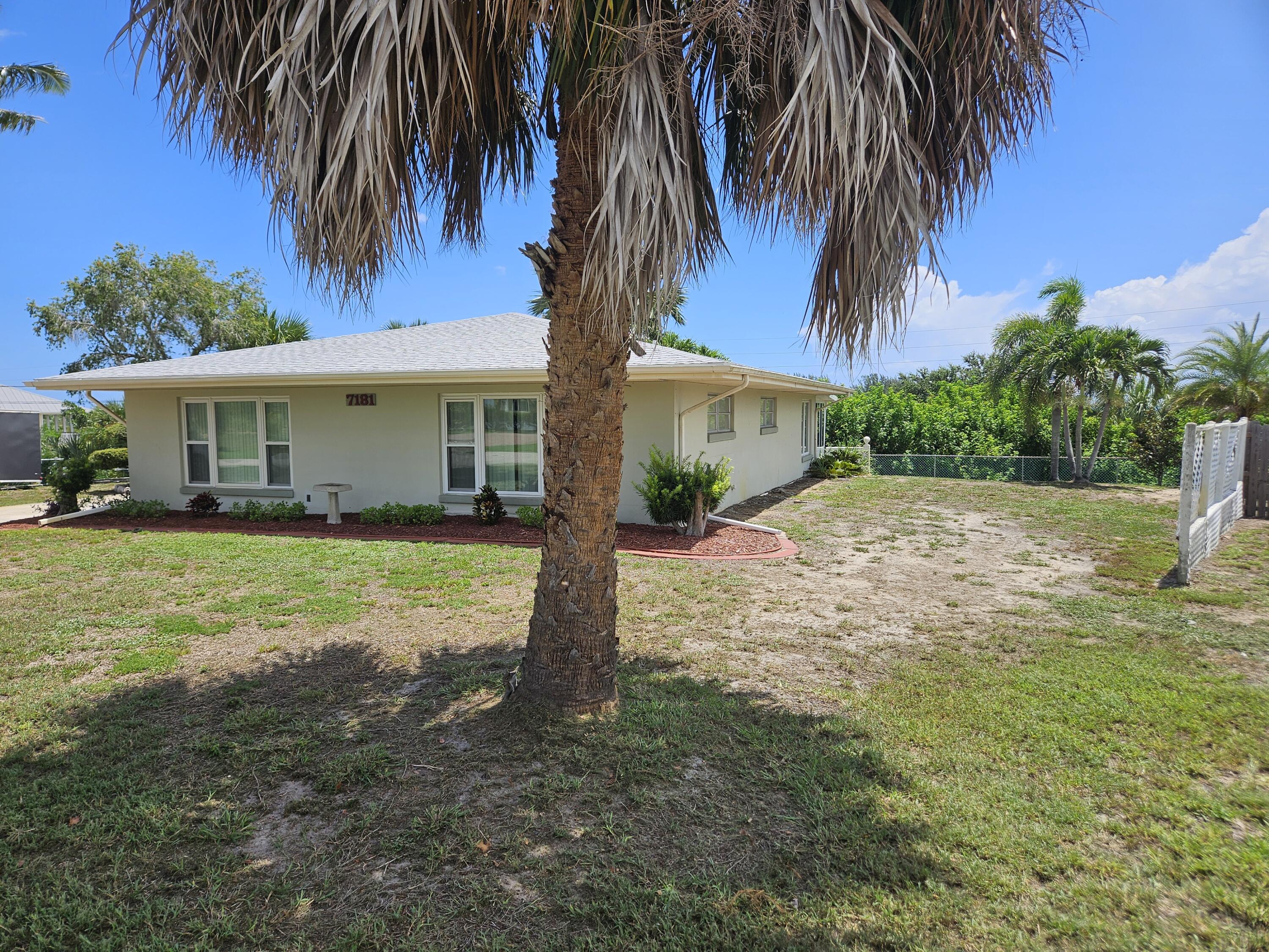 7181 Blue Shore Road Grant, FL 32949 - Photo 5 of 40 a front view of house with small garden and palm trees