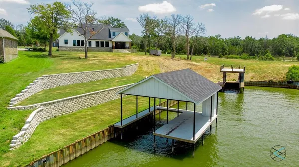 a view of a swimming pool with lawn chairs and a big yard