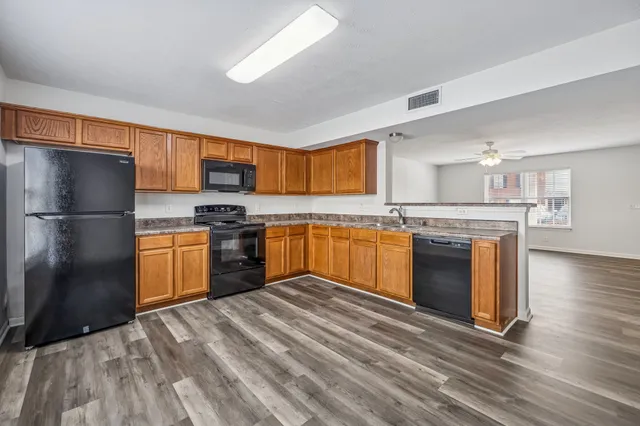 a kitchen with granite countertop stainless steel appliances and wooden cabinets
