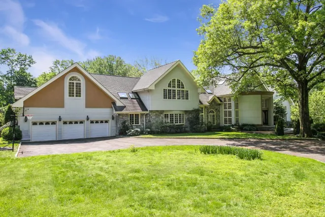 a front view of a house with a yard and trees