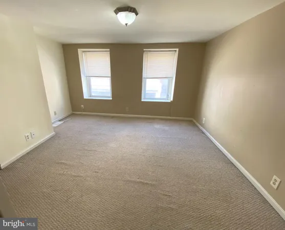 an empty room with closet and mirror