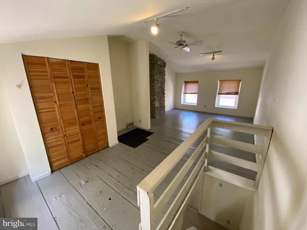 an empty room with wooden floor and entrance