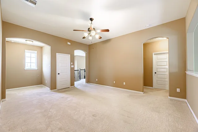 an empty room with fan and entryway
