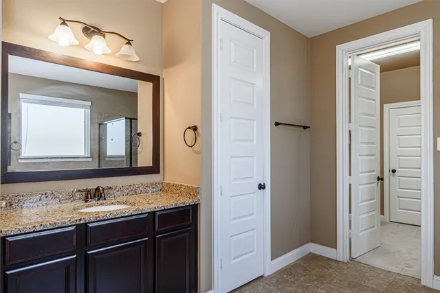 a bathroom with a granite countertop tub sink and mirror