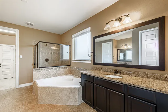 a bathroom with a tub a sink and mirror