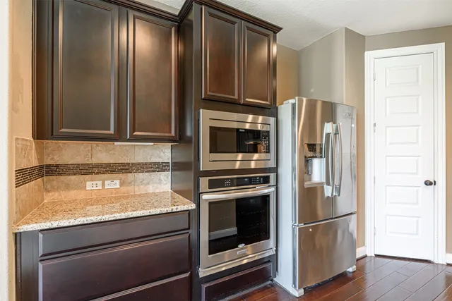 a kitchen with granite countertop stainless steel appliances and refrigerator