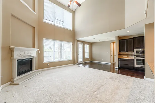 an empty room with windows and fireplace