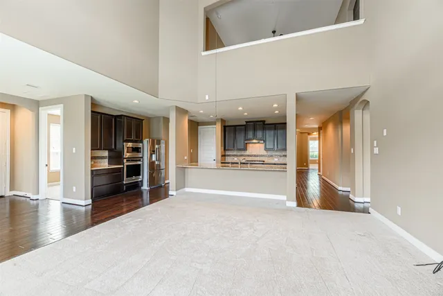 a view of large kitchen with refrigerator and cabinets