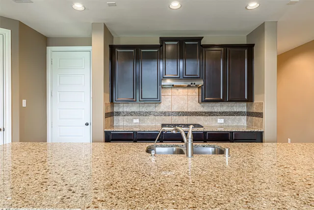 a large kitchen with kitchen island a large counter top and a sink