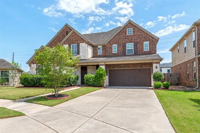 a front view of a house with a yard and potted plants