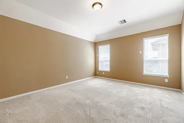 an empty room with windows and closet