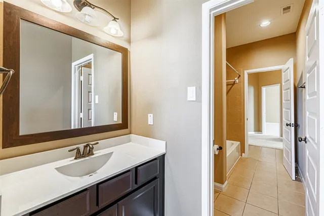 a bathroom with a tub shower and a sink