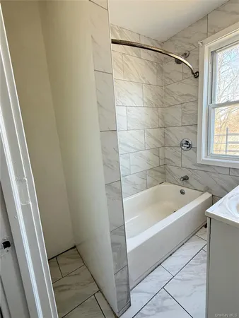 a bathroom with a tub a sink and a shower