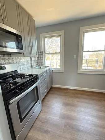 a kitchen with a stove a microwave and window