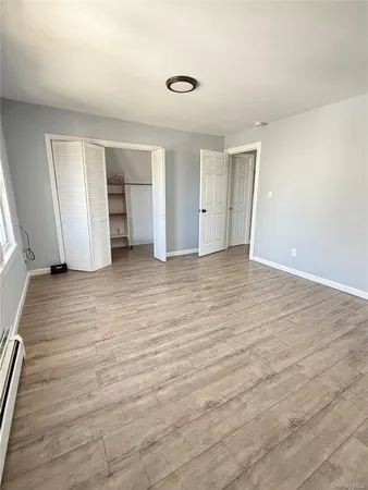 an empty room with wooden floor and closet