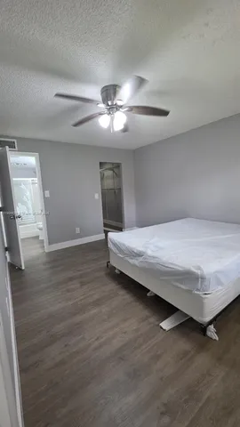 a bedroom with a bed and a ceiling fan