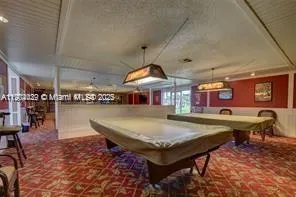 a room with pool table and chairs