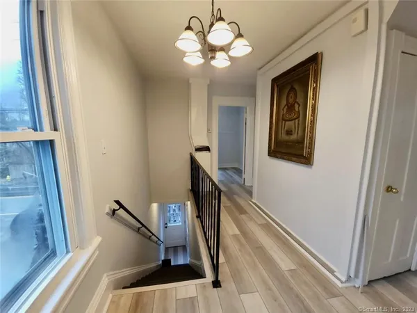 a view of a hallway with couches and a chandelier