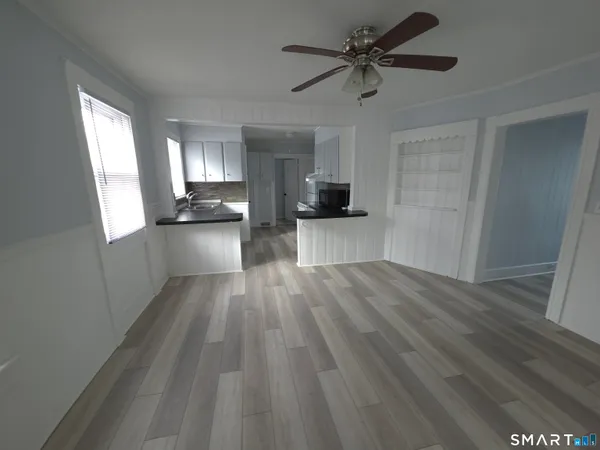 a view of a living room hardwood floor and a ceiling fan