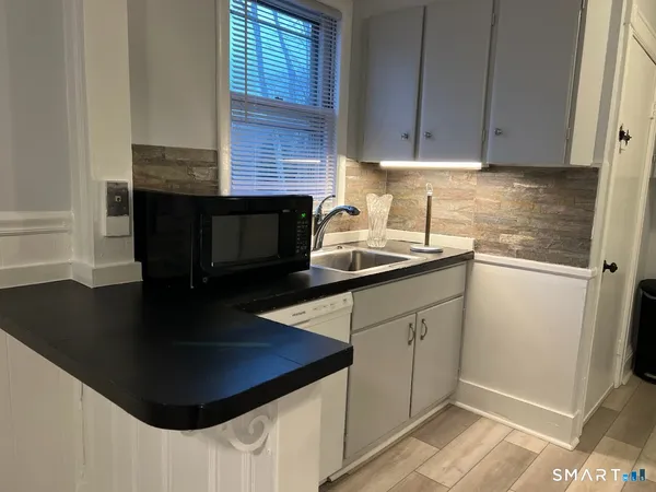 a kitchen with stainless steel appliances granite countertop a sink a stove and a refrigerator