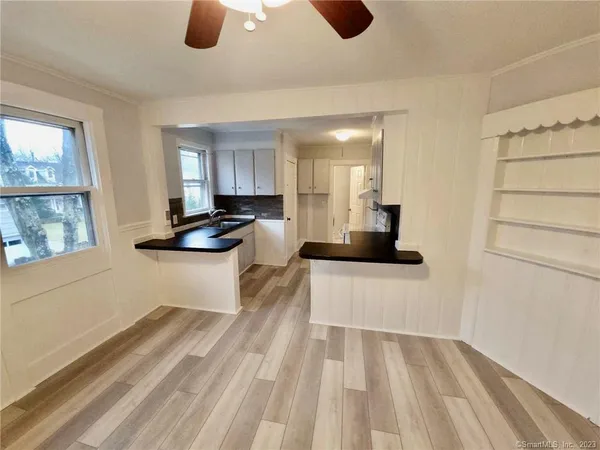 a living room with stainless steel appliances kitchen island granite countertop furniture and a window