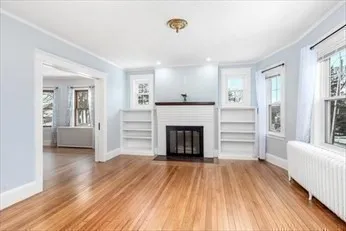 a view of a livingroom with wooden floor and a fireplace