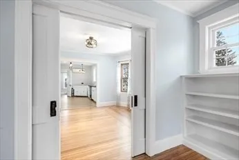 a view of a hallway with bathroom and wooden floor