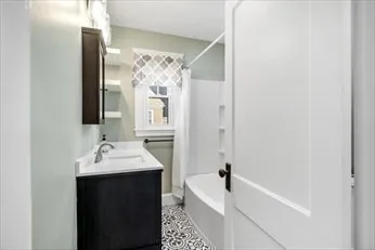 a bathroom with a tub sink and mirror